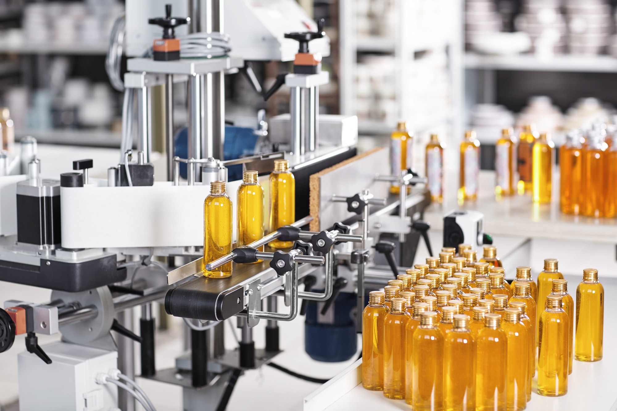 Horizontal shot of cosmetics or pharmacy plant with automated equipment. Transparent plastic bottles